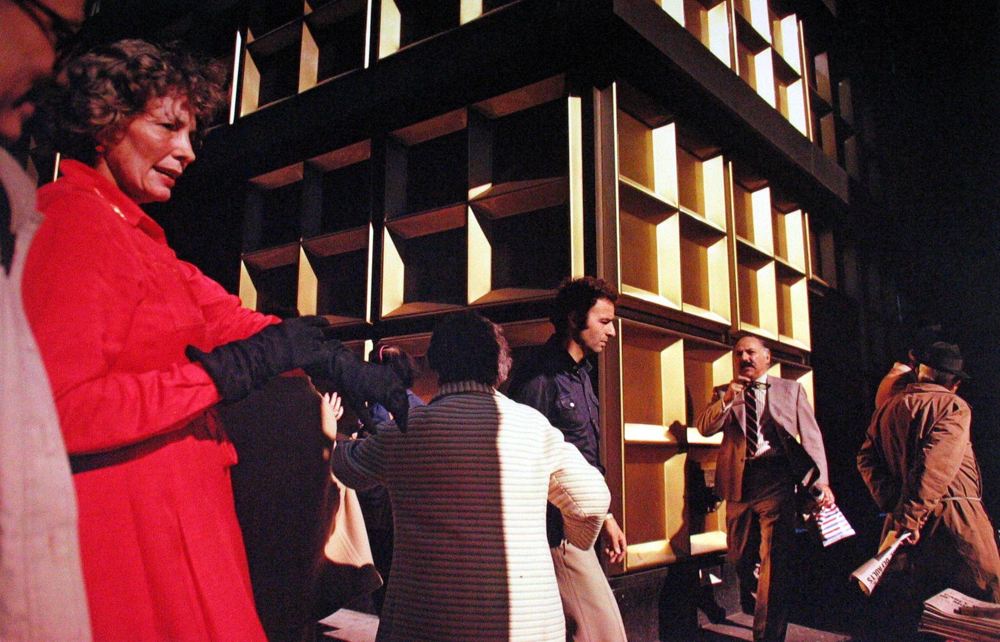 Photo of a corner of a building with square windows & people walking by in strong sunlight, by Joel Meyerowitz