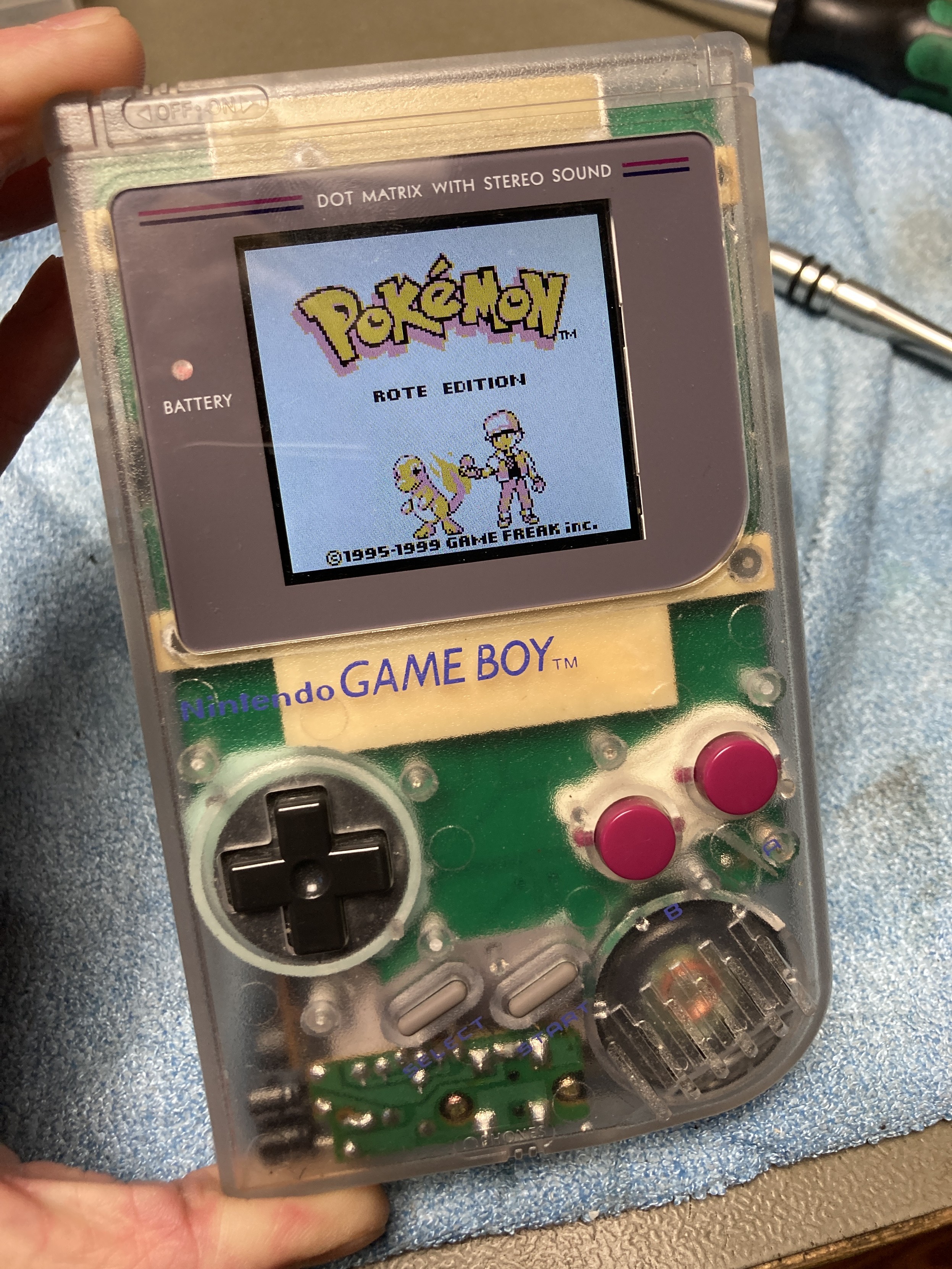 A clear DMG-01 Gameboy with an IPS display mod running the German version of Pokémon Red.